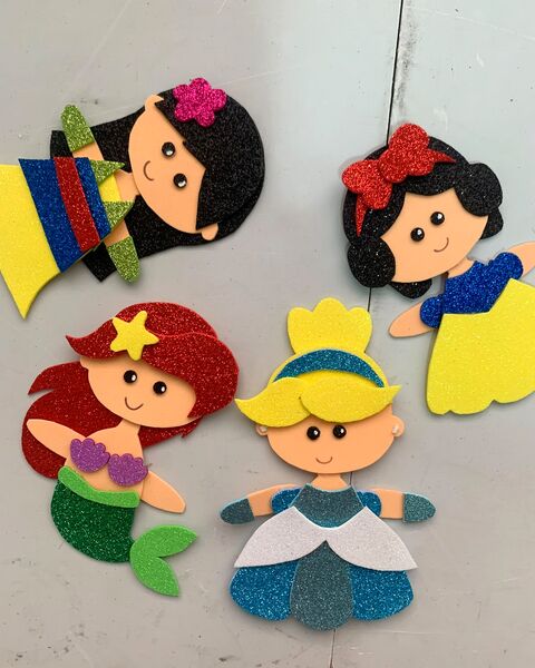 Cuatro princesas de foami escarchado que recorté y armé a mano, antes de descubrir el fieltro.